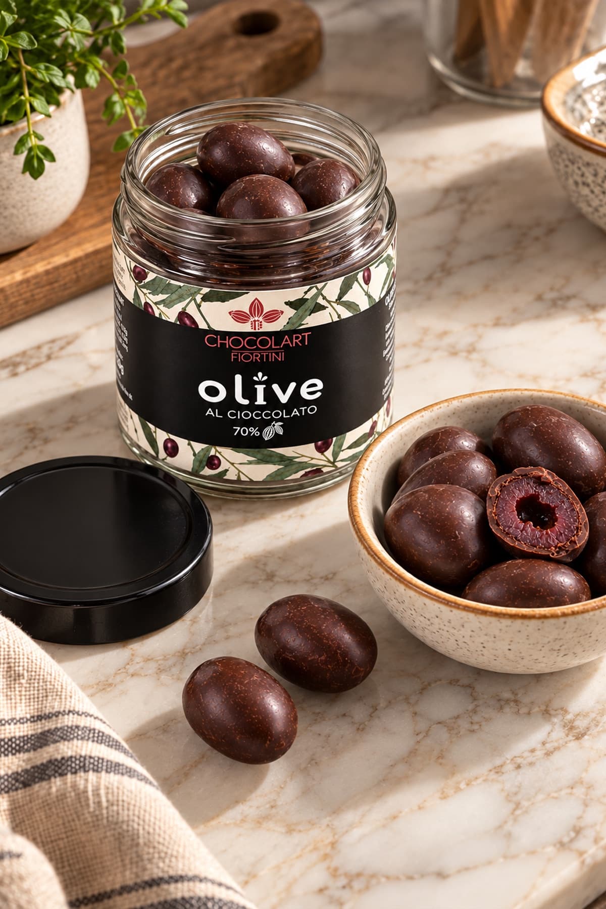 Olive al cioccolato servite in una ciotola accanto al barattolo aperto