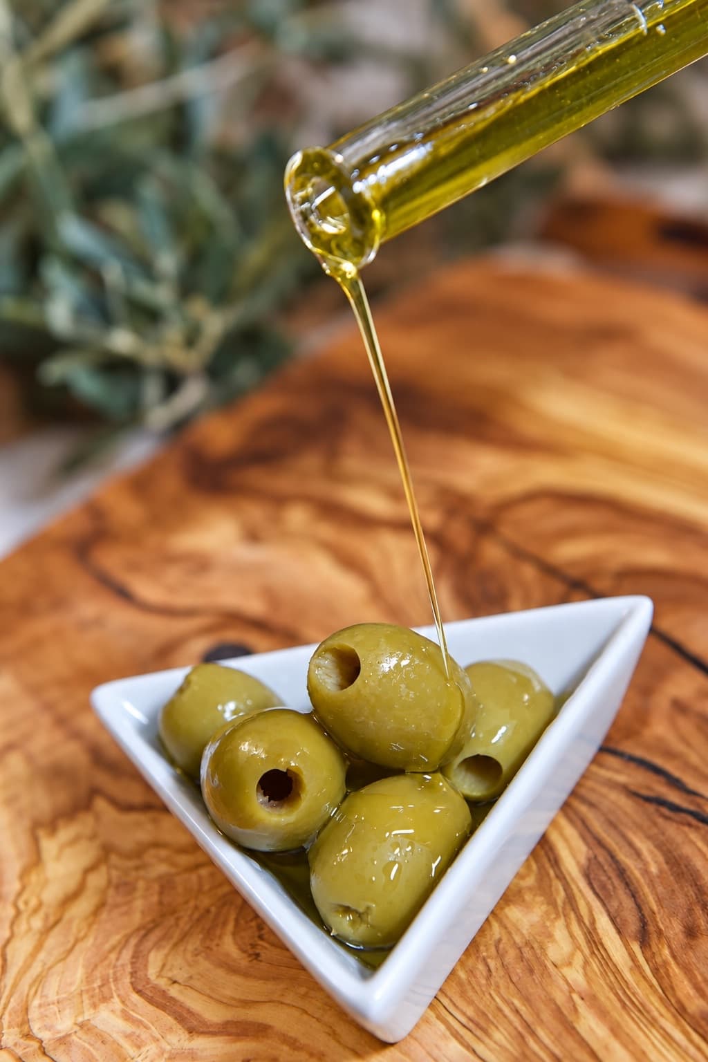 Un filo d’olio extravergine su una ciotola di olive verdi Chalkidiki